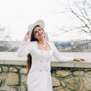 a woman wearing a white dress and hat