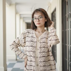 A woman standing in a hallway with her hands on her head